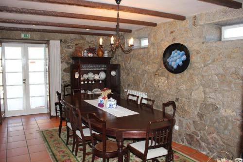 a dining room with a table and a stone wall at Casa do Nato -Turismo Rural in Viana do Castelo
