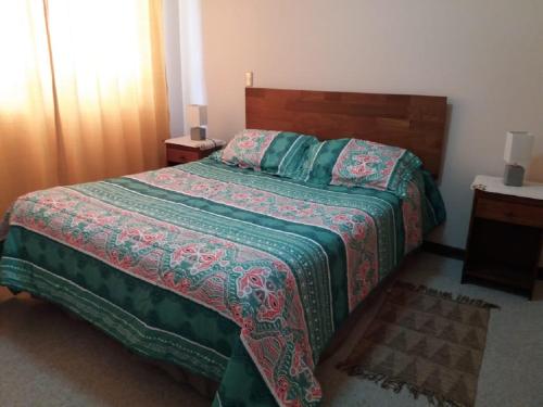 1 dormitorio con 1 cama con edredón verde en Departamento Pucon, en Pucón