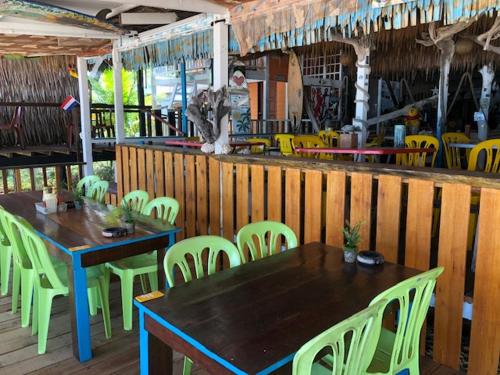 a restaurant with tables and chairs and a table and chairs at Beach Shack Chalet - Garden View Aframe Big Unit in Tioman Island
