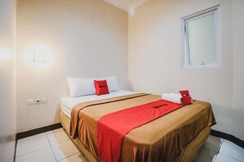 Un dormitorio con una cama con almohadas rojas. en RedDoorz @ Pandu Raya Bogor, en Bogor