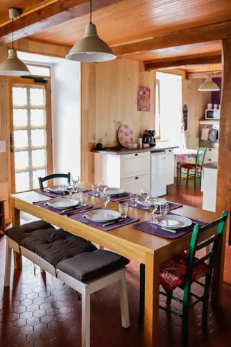 une table en bois avec des chaises et une salle à manger dans l'établissement Maison du Coué Pyrénées Mourtis Gîte pour 2 à 12 pers, à Sengouagnet