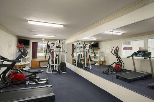a gym with several treadmills and cardio machines at Ramada by Wyndham Bloomington I-55 and I-74 IL in Bloomington