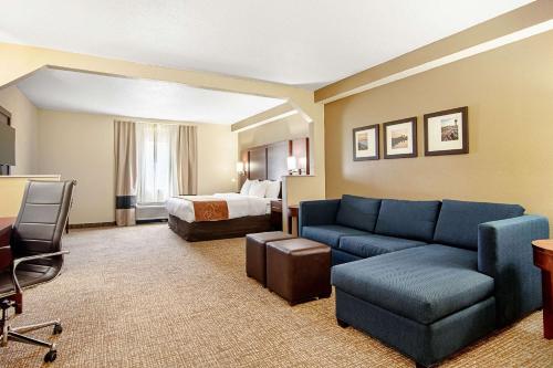 a hotel room with a couch and a bed at Comfort Suites Knoxville Airport in Alcoa