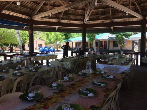 een groep tafels en stoelen met eten erop bij Se San Beach Resort-Isla de Gigantes in Carles
