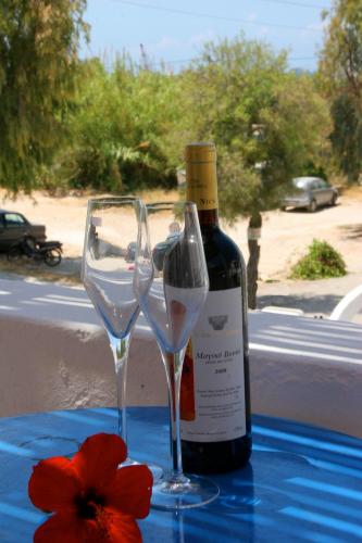 une bouteille de vin et deux verres sur une table dans l'établissement Rubini Rooms, à Parikia