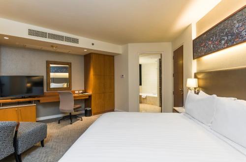 a hotel room with a bed and a desk at Chatrium Sathon Bangkok in Bangkok