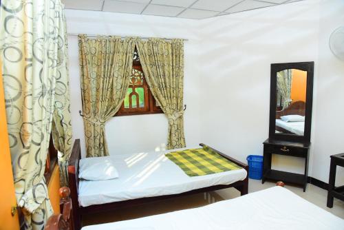 a bedroom with two beds and a mirror at Airport Tourist Hostel in Katunayake