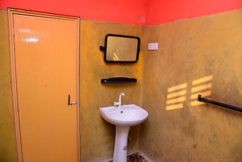 a bathroom with a sink and a mirror on the wall at Airport Tourist Hostel in Katunayake
