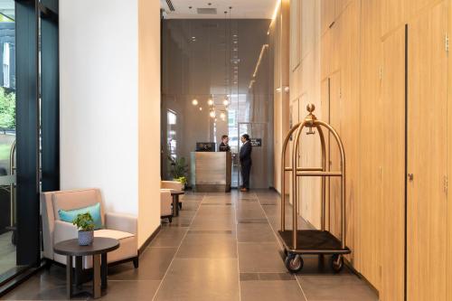 a hallway with chairs and a table in a building at Novotel Melbourne Central in Melbourne