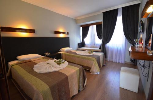 a hotel room with two beds and a window at Hisar Holiday Club in Oludeniz