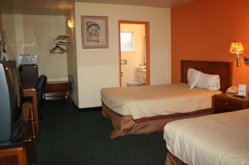 a hotel room with two beds and a television at Americas Best Value Inn - Livermore in Livermore