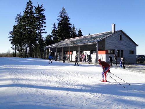 a person on skis in the snow in front of a building at Birkholmhof in Bärnau