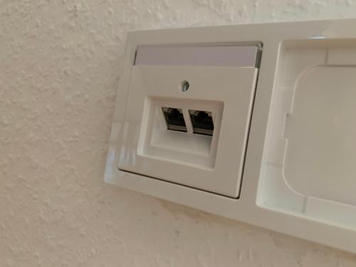 a white lightswitch on a wall in a bathroom at Comfort Lodging Stueckenfeld in Hannover