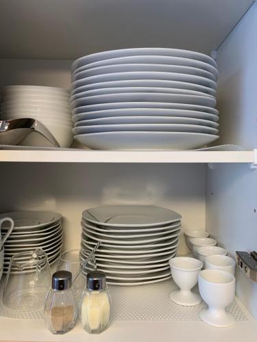 a shelf filled with plates and bowls and dishes at Comfort Lodging Stueckenfeld in Hannover