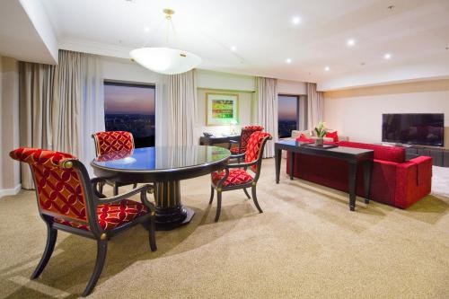 a living room with a red couch and a table and chairs at Stamford Plaza Sydney Airport Hotel & Conference Centre in Sydney