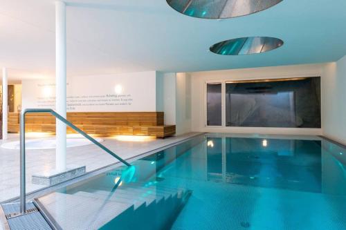 a large swimming pool in a building with a large tv at Legendär Zermatt in Zermatt