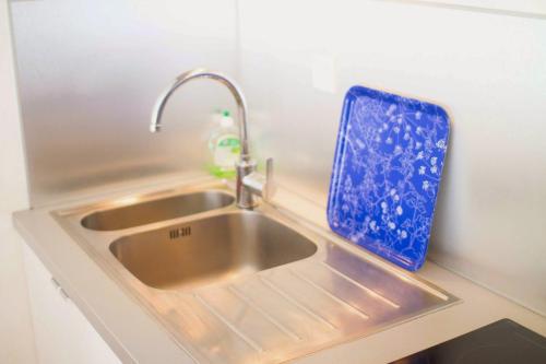- un évier de cuisine avec un plateau bleu à côté dans l'établissement StudioLille - Saint Michel, à Lille