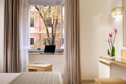a hotel room with a bed and a window with a laptop at Magica Luna Boutique Hotel - Roma in Rome