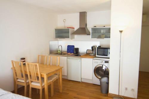 Il comprend une petite cuisine avec une table, des chaises et un four micro-ondes. dans l'établissement StudioLille - Saint Michel, à Lille