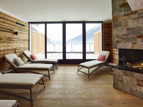 a waiting room with chairs and a fireplace at Alpeiner - Nature Resort Tirol in Neustift im Stubaital