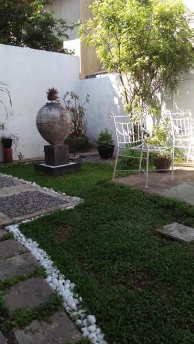 a garden with two chairs and a vase in the yard at Mini's Residence in Colombo