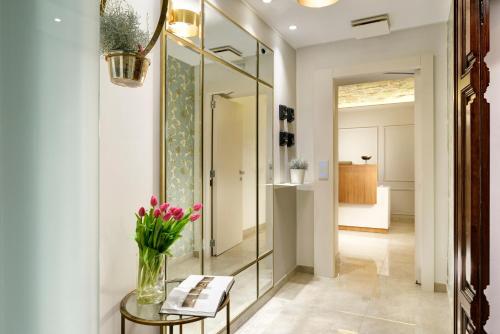 a hallway with a mirror and a table with flowers on it at Magica Luna Boutique Hotel - Roma in Rome