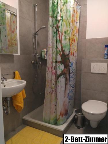 a bathroom with a shower curtain and a sink at Gästehaus Schumann in Essingen