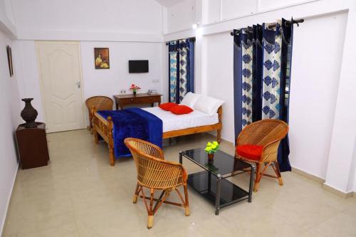 1 dormitorio con cama, sillas y mesa en Marari PeterLand, en Alleppey
