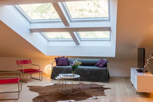 a living room with a vaulted ceiling with skylights at Legendär Zermatt in Zermatt