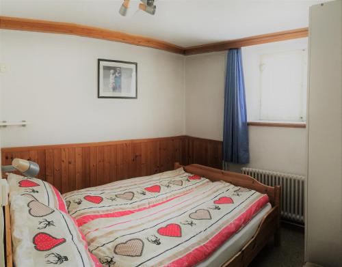 ein Schlafzimmer mit einem Bett mit einer Bettdecke mit Herz darauf in der Unterkunft Chalet Waldesruh 3 Zimmerwohnung in Arosa