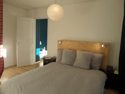 une chambre avec un grand lit blanc avec une lampe dans l'établissement Lille Grand Palais, Europe, Bienvenue chez Nestyou, Lille, à Lille
