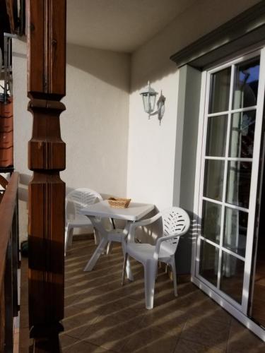 a dining room with a table and white chairs at Apartments Timjana in Bohinj