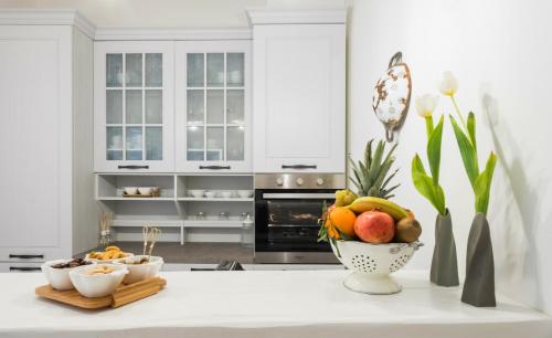 a white kitchen with a bowl of fruit on a counter at Amatè Suite in Lecce