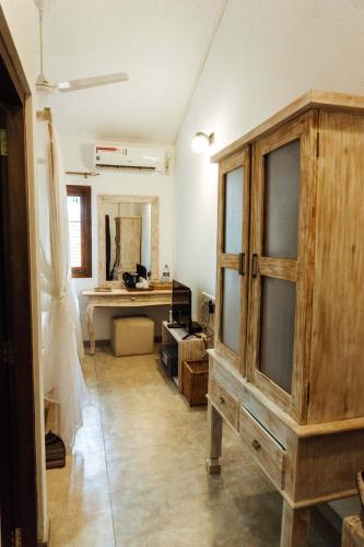 a room with a large wooden cabinet and a desk at Handun Villas in Talalla