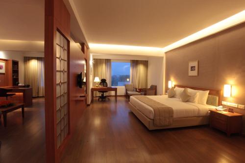 a hotel room with a bed and a living room at Monsoon Empress Kochi in Cochin