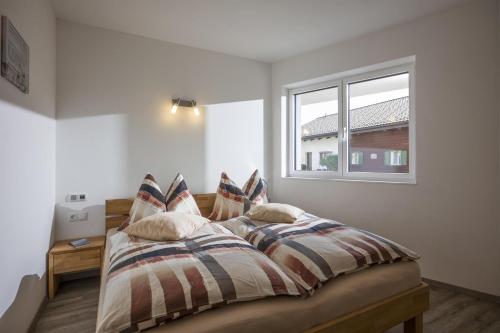 a bedroom with a bed with pillows and a window at Appartement de Jager in Söll