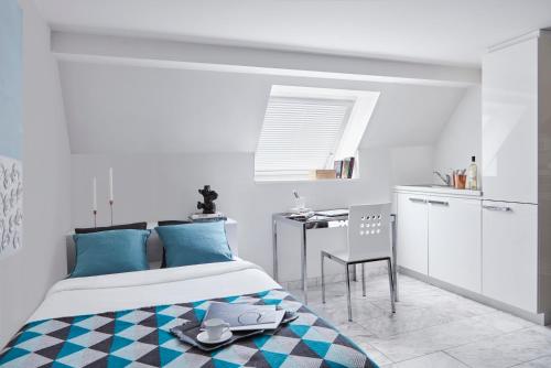 a white and blue bedroom with a bed and a table at VISIONAPARTMENTS Binzmühlestrasse 50 - contactless check-in in Zürich
