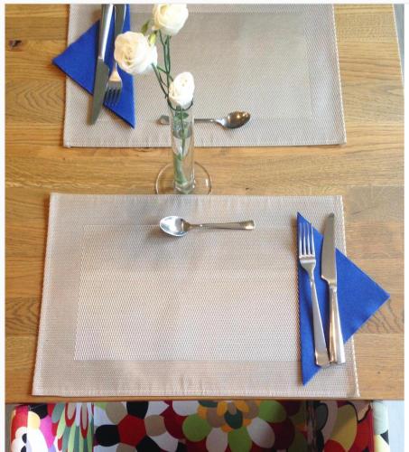 a table with two plates and a vase with white flowers at Blu Hotel in Lavagna