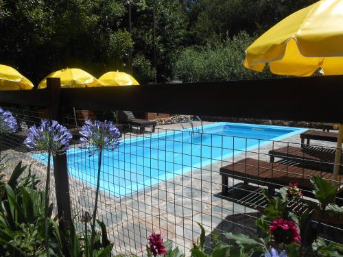 a swimming pool with tables and umbrellas at Complejo Caramelo in Villa Ventana