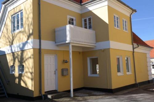 a yellow and white house with a balcony at Skagen lejlighed - Sct. Laurentiivej th in Skagen
