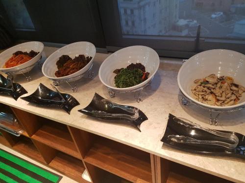 a table with four bowls of food on it at Hotel Artheim in Gwangju