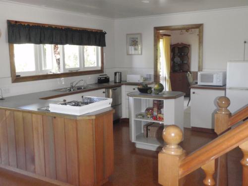 a kitchen with a sink and a stove top oven at Haydanblair House in Burnt Pine