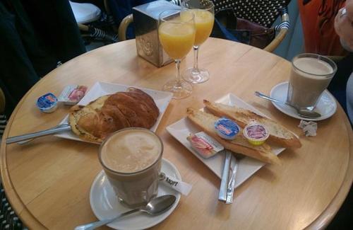 una mesa con café y pan y dos vasos de zumo de naranja en Hotel Almoradi, en Almoradí