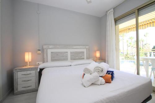 ミアミ・プラトーヤにあるARENDA Apartamento Flamencos 213のベッドルーム1室(タオル付きのベッド1台、窓付)