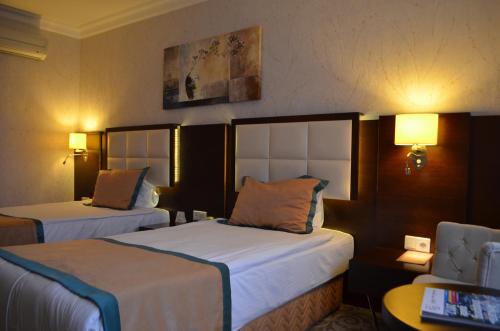 Llit o llits en una habitació de Asrin Park Hotel & Spa Convention Center