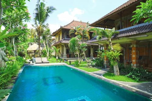 a villa with a swimming pool in front of a house at Ubud Kerta City Hotel in Ubud