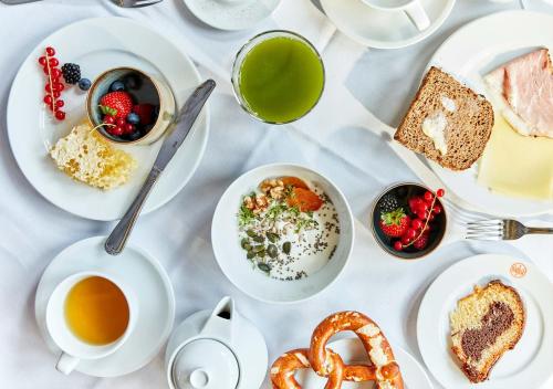 a table with plates of food and cups of tea and pretzels at Spa & Resort Bachmair Weissach, LUXURY FAMILY RESORT in Rottach-Egern