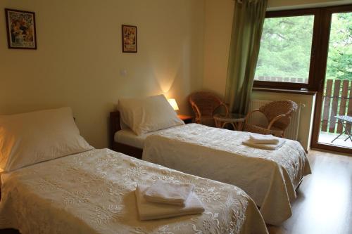 a hotel room with two beds and a window at Penzión Harmónia in Modra