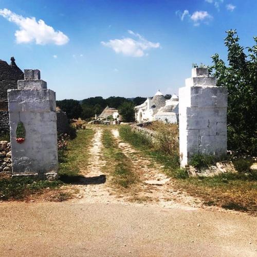a dirt road with two stone structures on the side at Borgo trulli 1789 in Ostuni