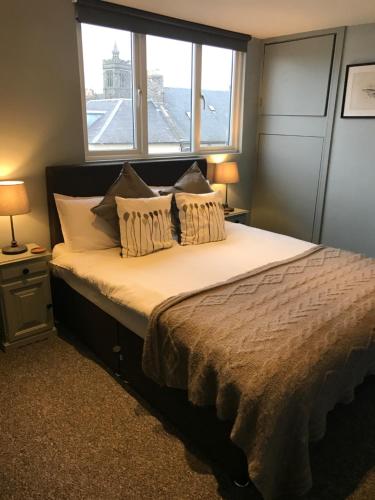 a bedroom with a large bed with a window at The Central Guesthouse in Kelso